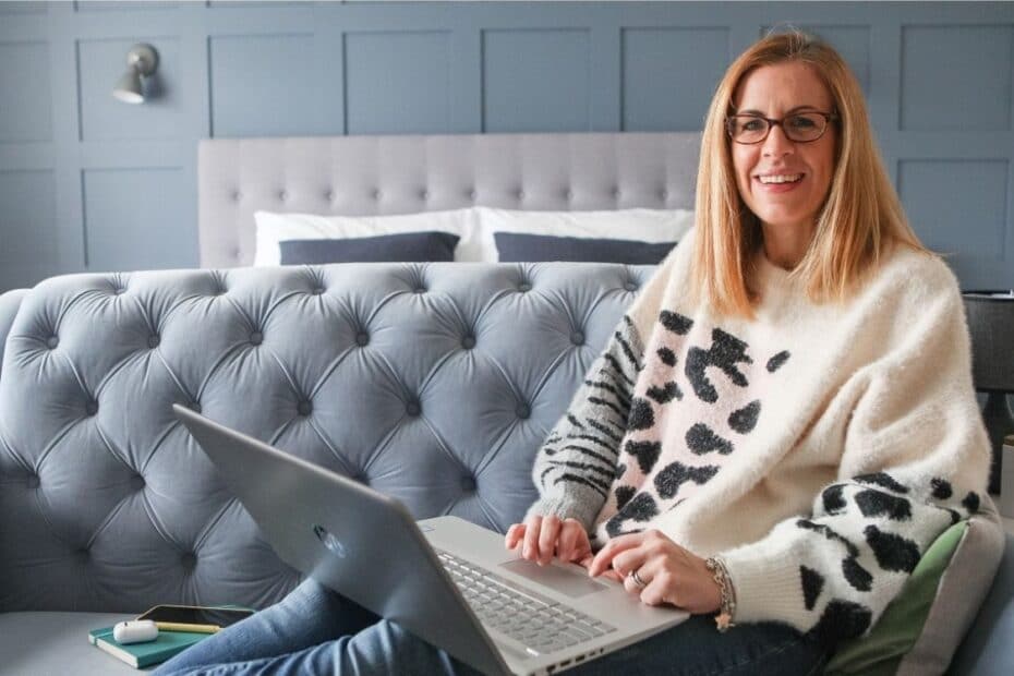Vicki Goldblatt working on laptop and sat on sofa