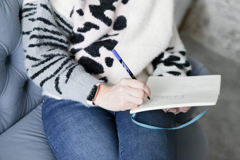 close up of female entrepreneur making notes in note pad