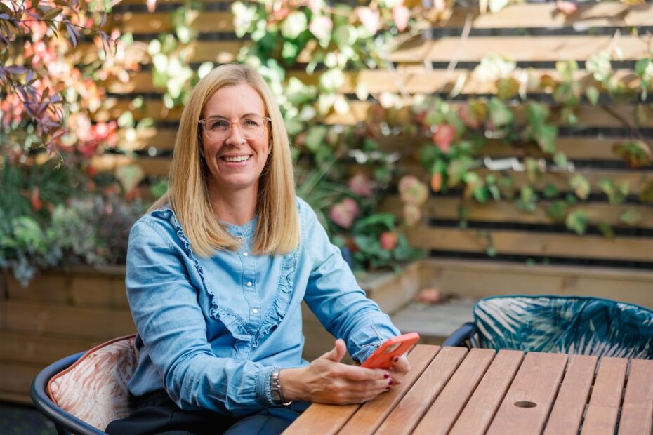 Vicki Goldblatt sat outside at garden table working on her mobile phone for tech tool tips
