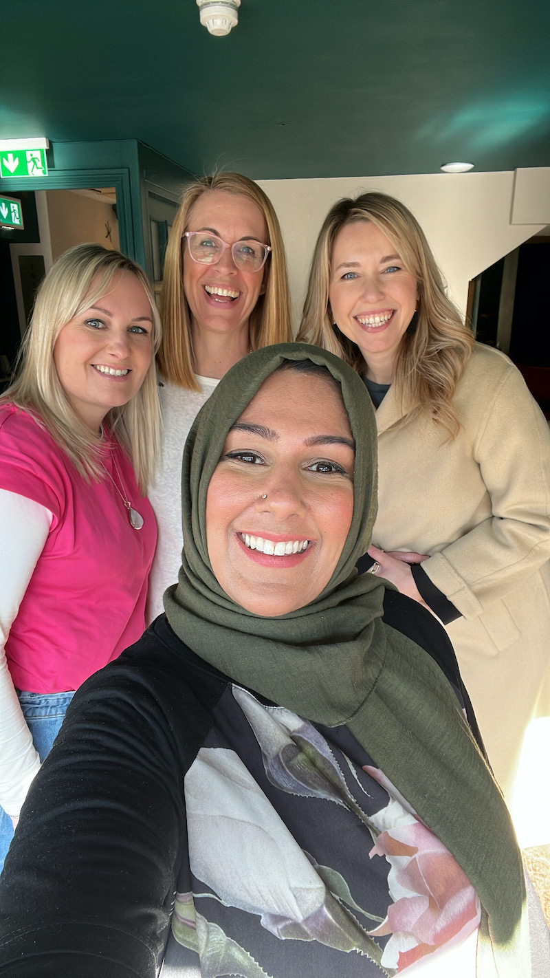 group selfie of four woman smiling together
